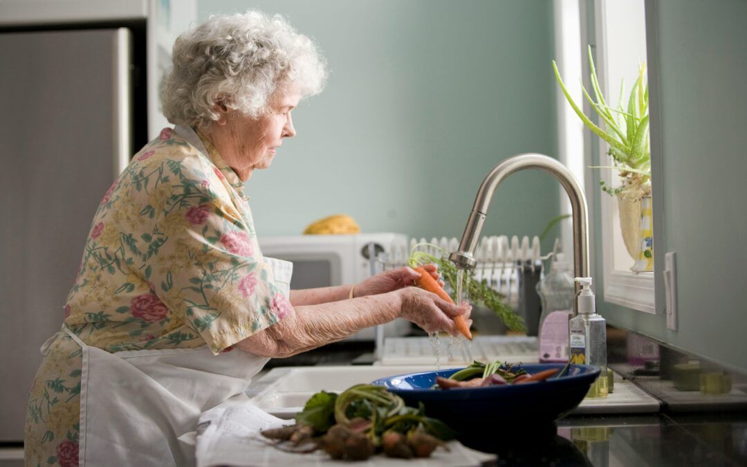 Woman washing fresh vegetables in clean kitchen