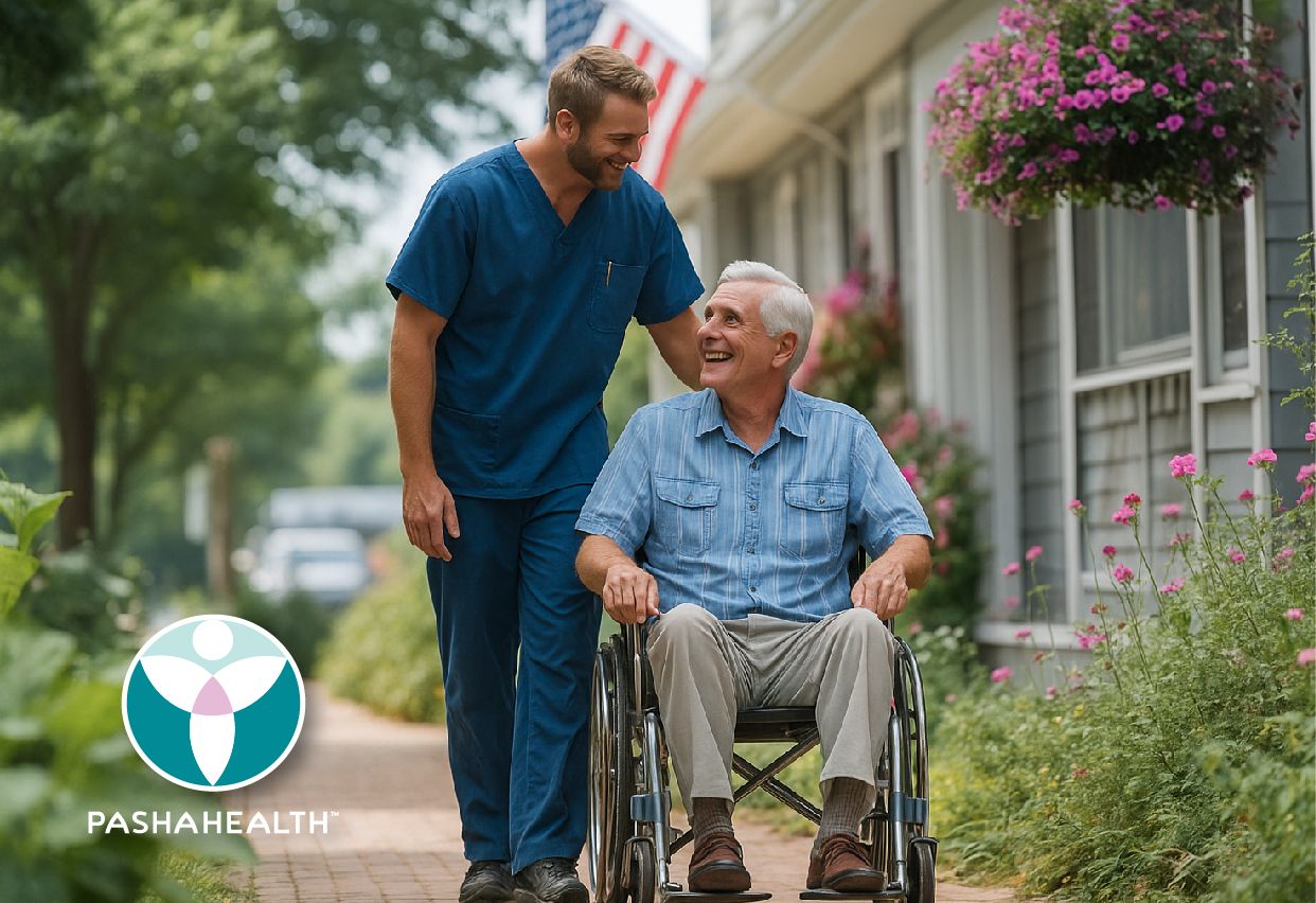 Caregiver walking with a man in a wheelchair outside his home
